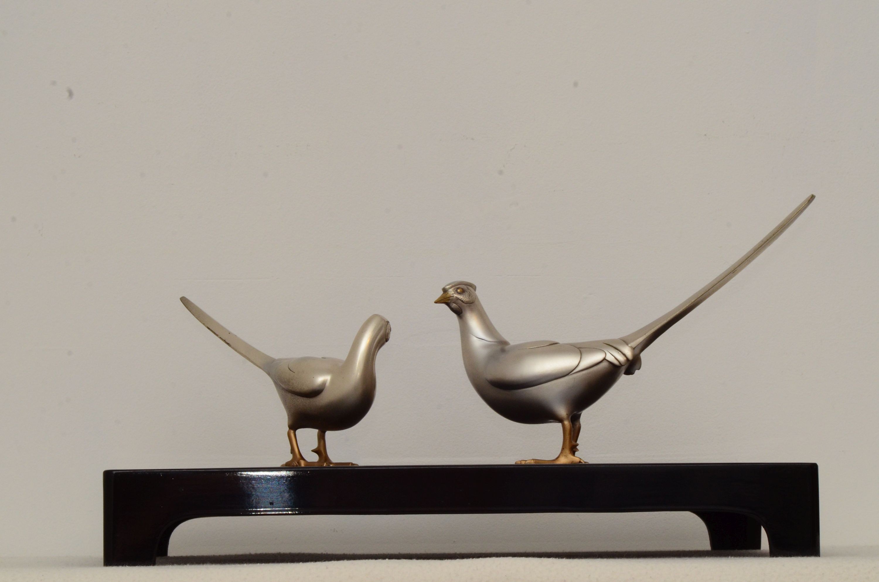 Two 20th century Japanese patinated bronze pheasants with lacquer stand, in original box